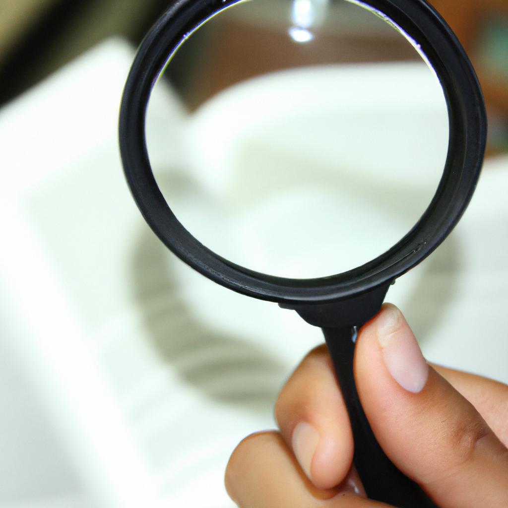 Person holding magnifying glass, reading